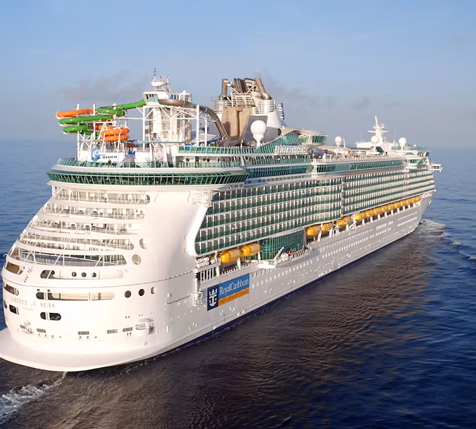 Aerial view of Royal Caribbean's Liberty of the Seas cruise ship sailing on open water, showcasing its innovative design and vibrant amenities.